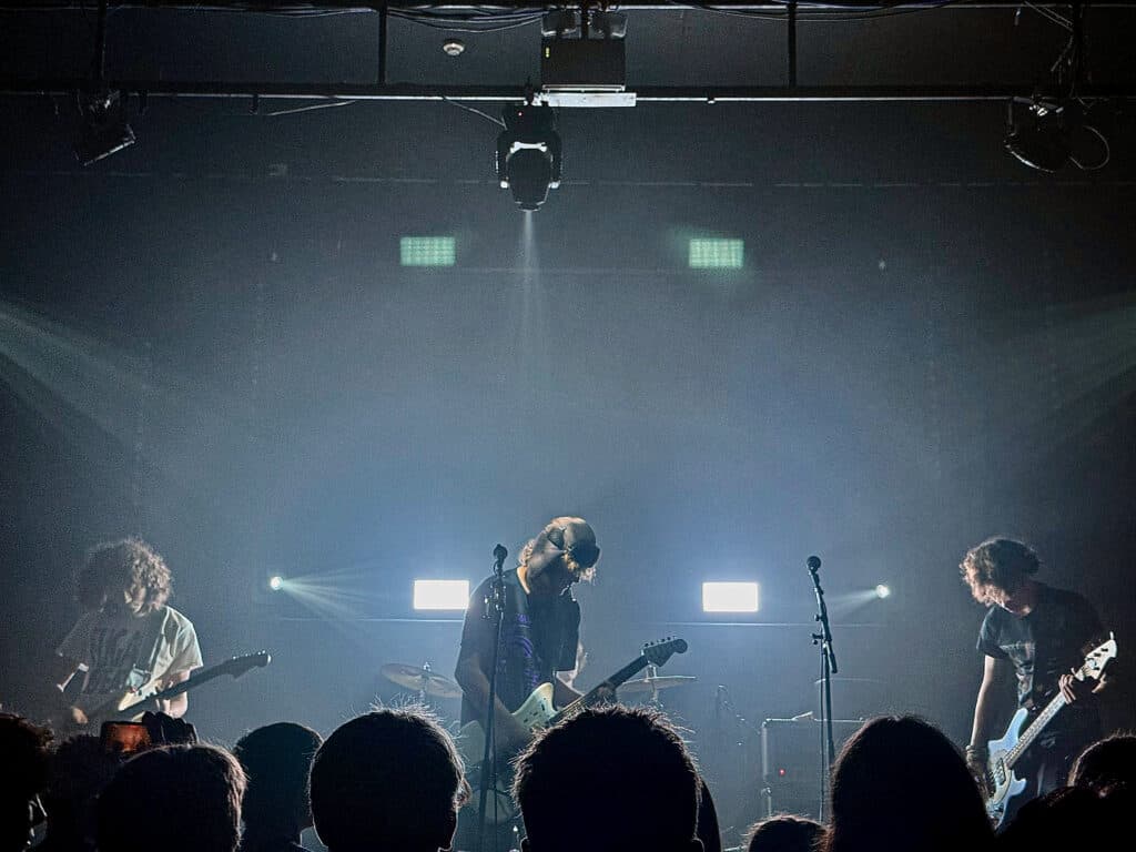 Aphid performing at The Brickyard beneath blue-white stage lights